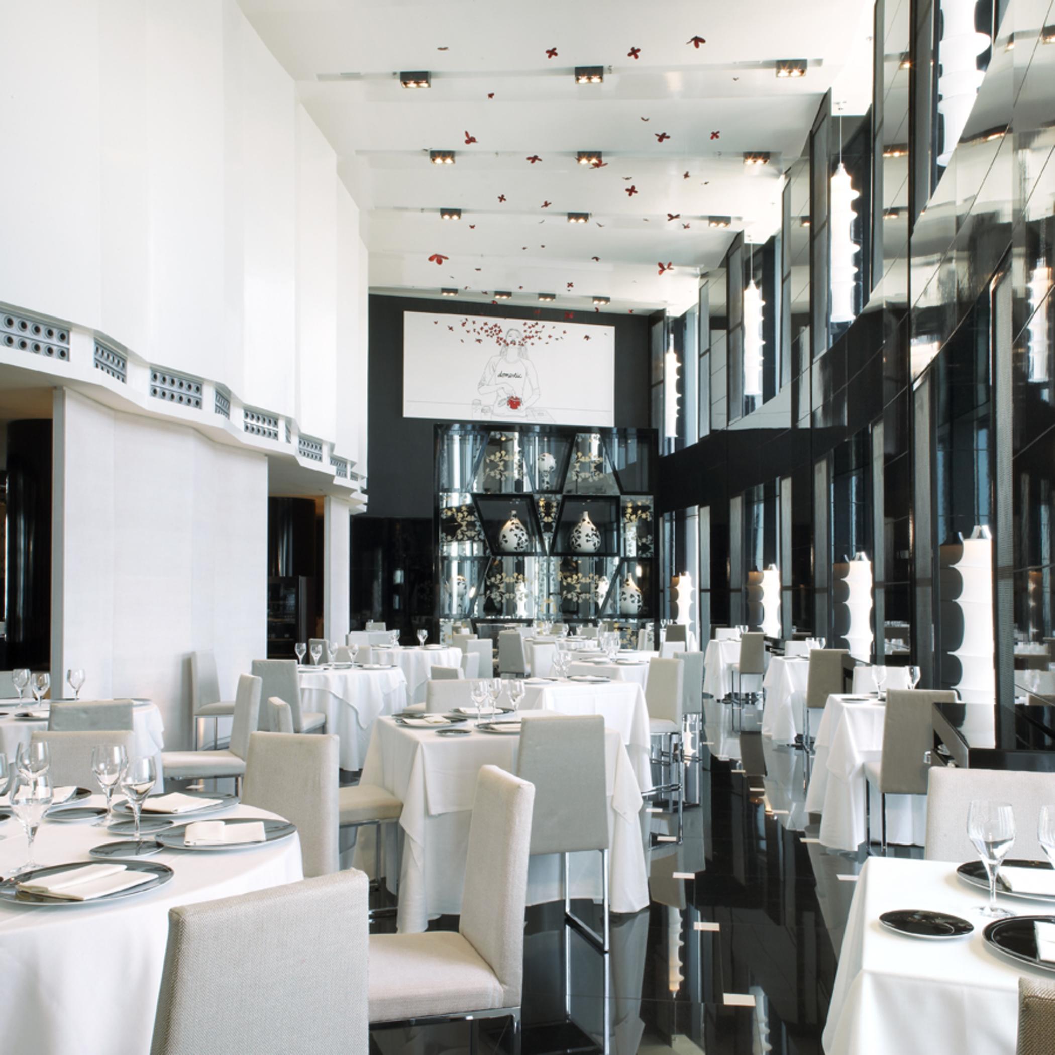 Eurostars Madrid Tower Hotell Exteriör bild The photo shows a modern and elegant restaurant interior. The space features tables covered with white tablecloths, arranged neatly with plates and glassware. The decor includes large glass windows that allow natural light to fill the room, and the w