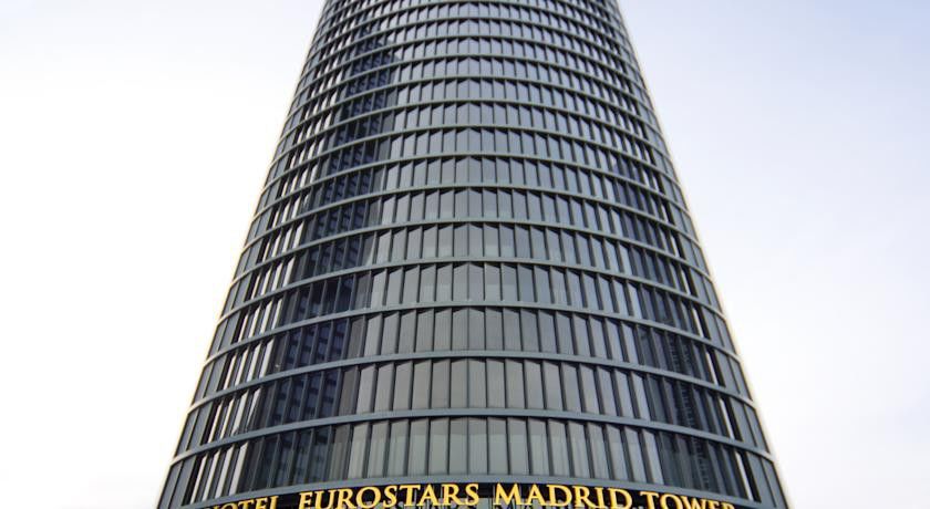 Eurostars Madrid Tower Hotell Exteriör bild The photo displays a tall, modern skyscraper known as the Eurostars Madrid Tower. The building features a sleek, glass facade with a cylindrical design. At the base, there's a prominent sign indicating the name of the hotel, “Eurostars Madrid Tower,”