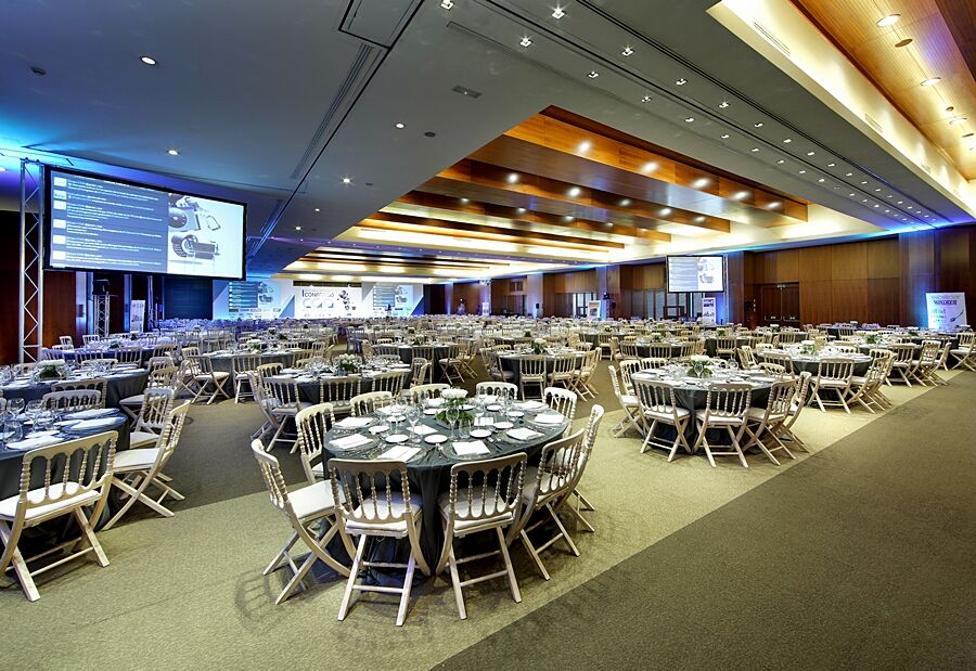 Eurostars Madrid Tower Hotell Exteriör bild The photo shows a spacious banquet hall or conference room set up for an event. There are several round tables arranged across the floor, each with elegant table settings, including plates, cutlery, and glasses. The decor features neutral tones, and 