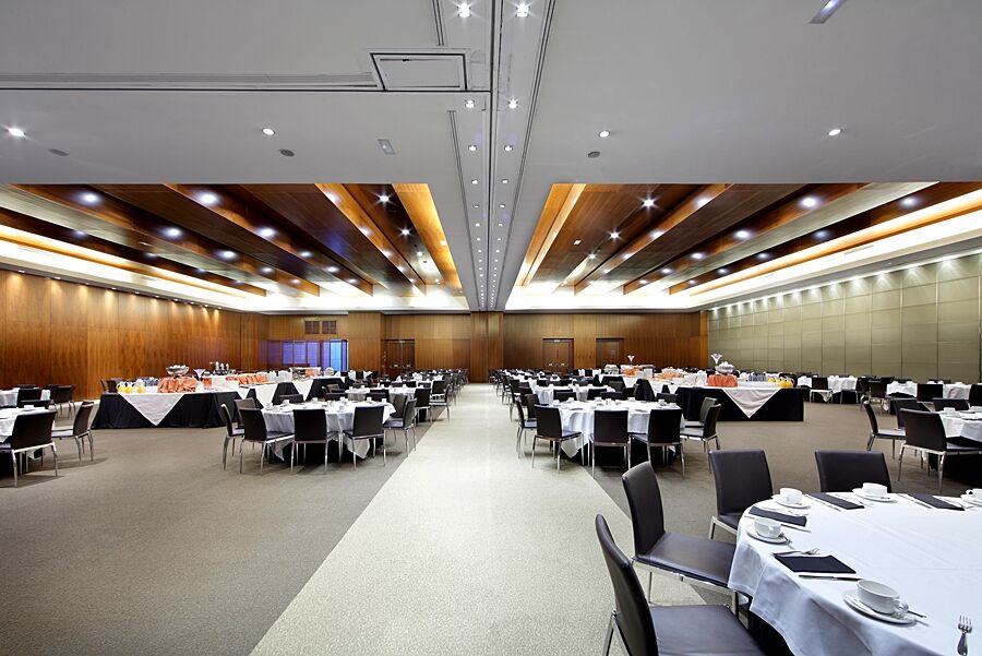 Eurostars Madrid Tower Hotell Exteriör bild The photo depicts a spacious banquet hall or conference room. It features a series of tables arranged in a grid pattern, covered with white tablecloths and adorned with black tablecloths at the edges. Each table is set with plates, cutlery, and glass